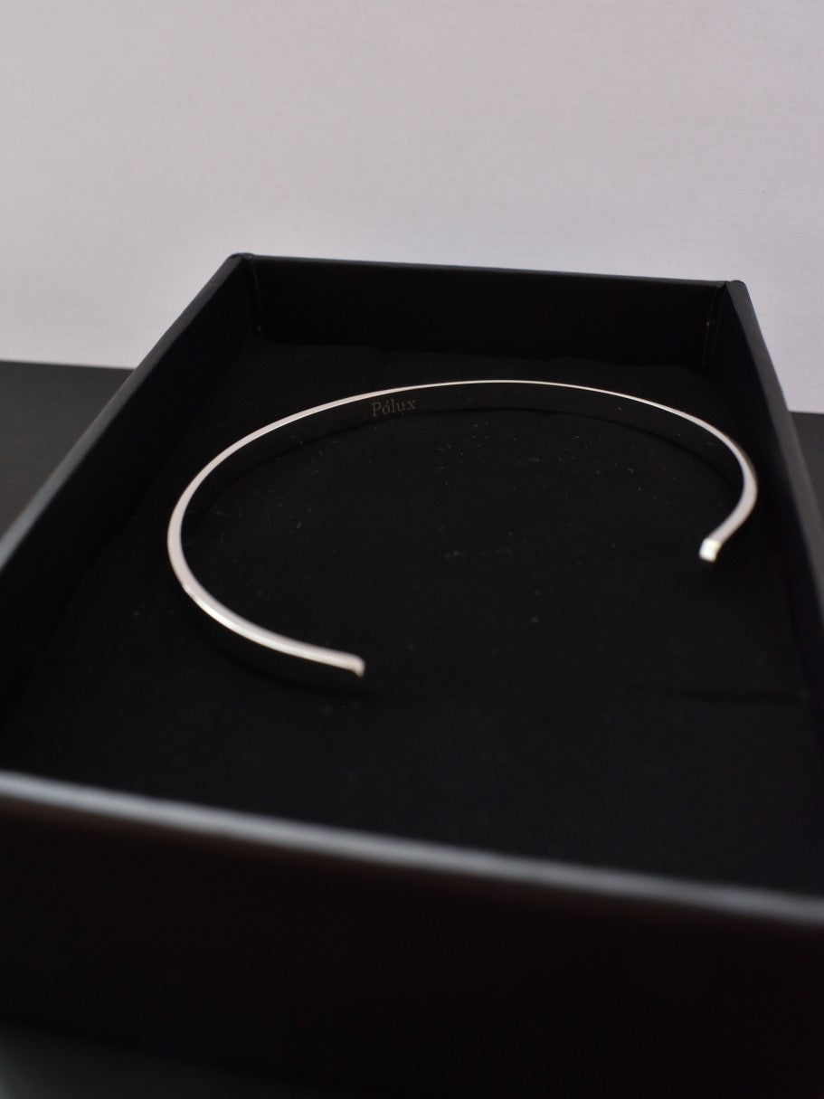 Brazalete plateado con grabado Pólux presentado en su empaque premium, listo para regalo.