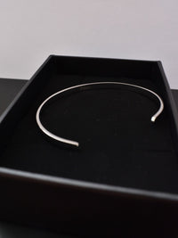 Brazalete plateado con grabado Pólux presentado en su empaque premium, listo para regalo.