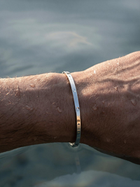 Brazalete plateado en la muñeca dentro del agua, resistente al agua para uso diario.