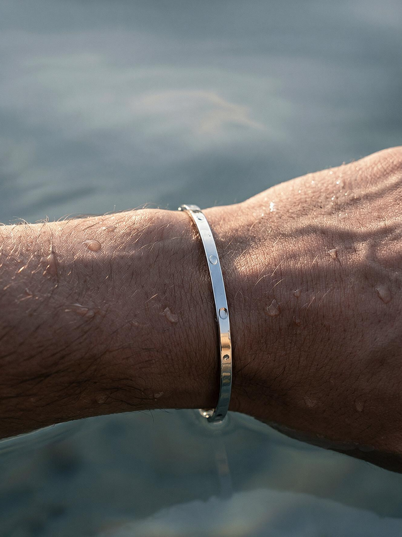 Brazalete plateado en la muñeca dentro del agua, resistente al agua para uso diario.