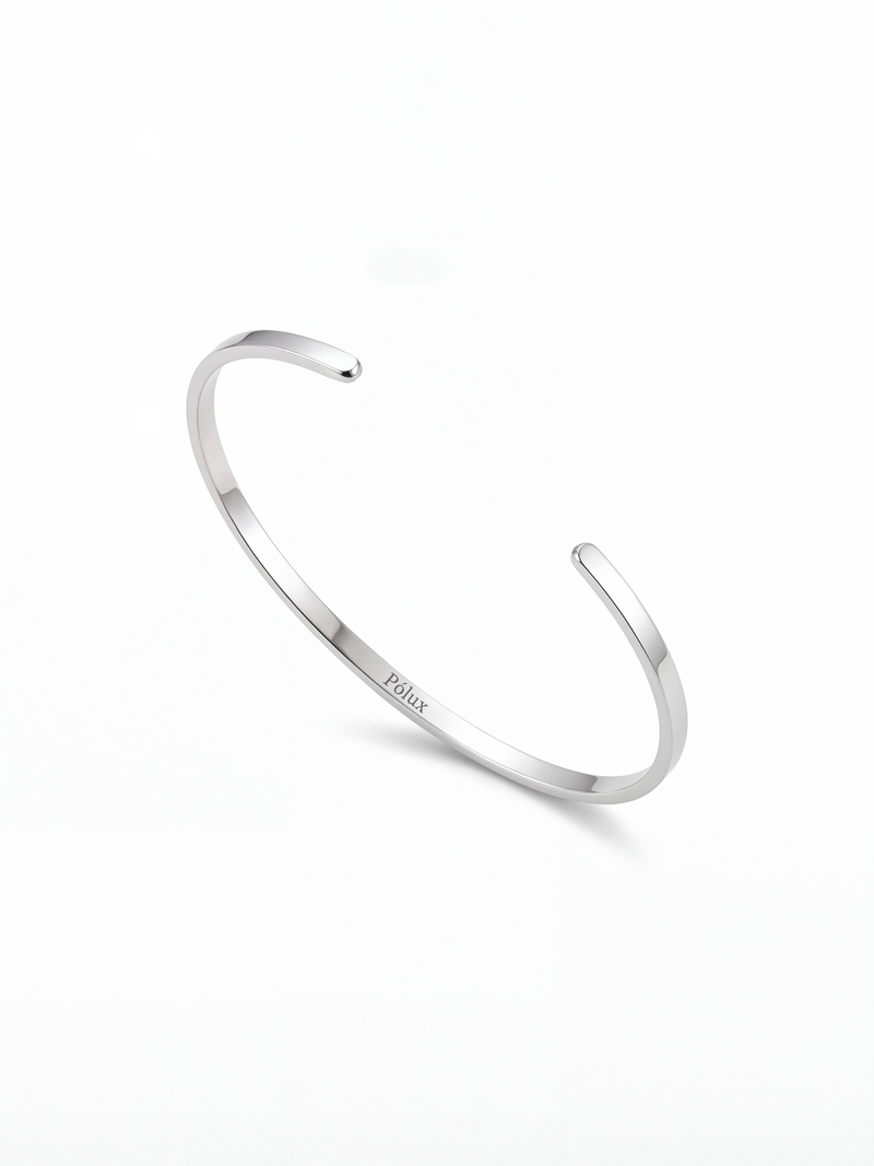 Brazalete plateado en acero quirúrgico con grabado Pólux, diseño minimalista unisex, acabado brillante.