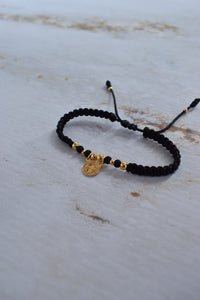 Pulsera de protección San Benito negra y dorada con empaque premium Pólux