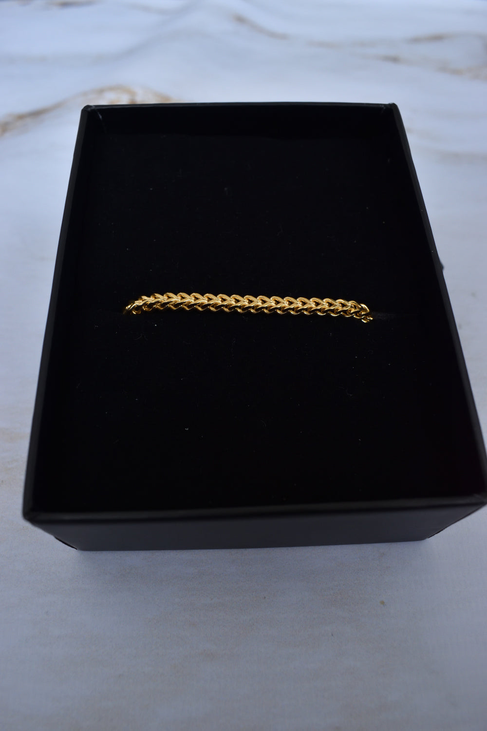Detalle de pulsera cadena franco oro 18K para hombre, broche langosta visible, caja Pólux Gentleman