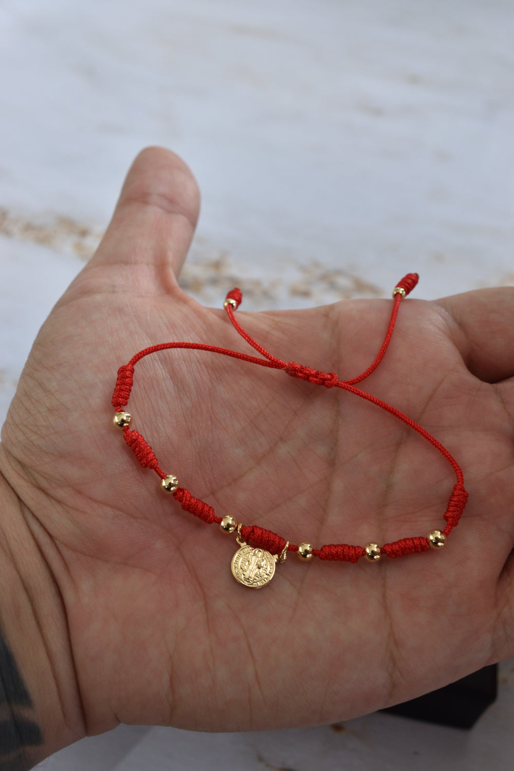 Pulsera protección San Benito unisex en cordón rojo trenzado ajustable