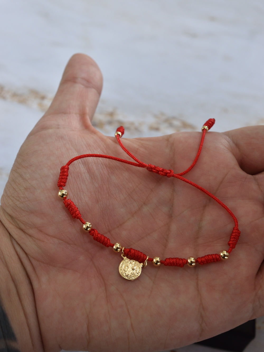 Pulsera protección San Benito unisex en cordón rojo trenzado ajustable