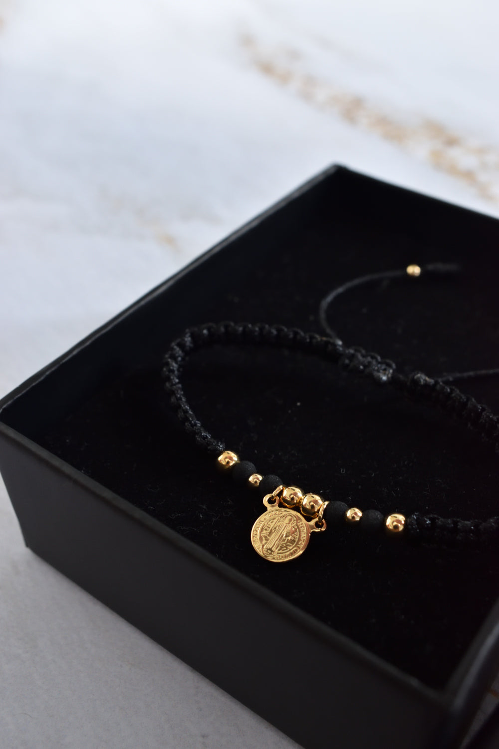 Pulsera unisex tejida en negro con contraste de balines dorados