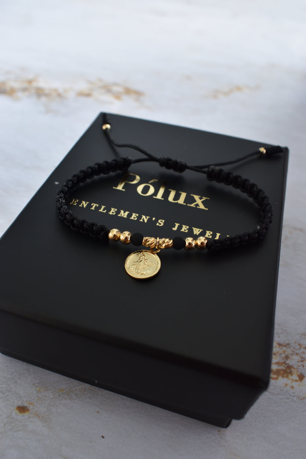 Pulsera unisex tejida en negro con detalles en oro laminado 18K