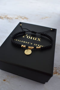 Pulsera unisex tejida en negro con detalles en oro laminado 18K