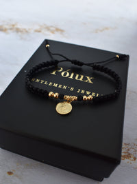 Pulsera unisex tejida en negro con detalles en oro laminado 18K