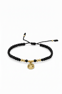 Pulsera San Miguel Arcángel tejida en macramé negro con oro laminado 18K sobre fondo blanco