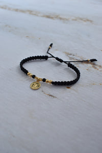 Pulsera San Miguel Arcángel tejida artesanalmente en macramé negro y oro 18K